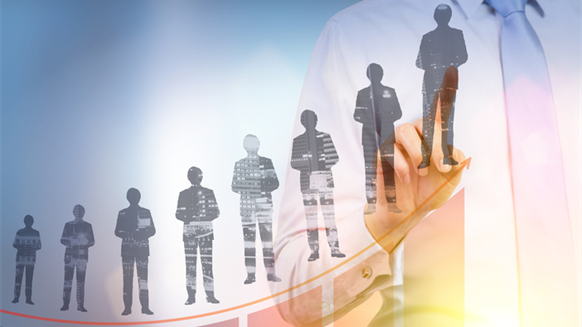 A business professional interacting with a digital interface showing silhouettes of people arranged along an upward trend line, symbolizing growth, hiring, or workforce development.