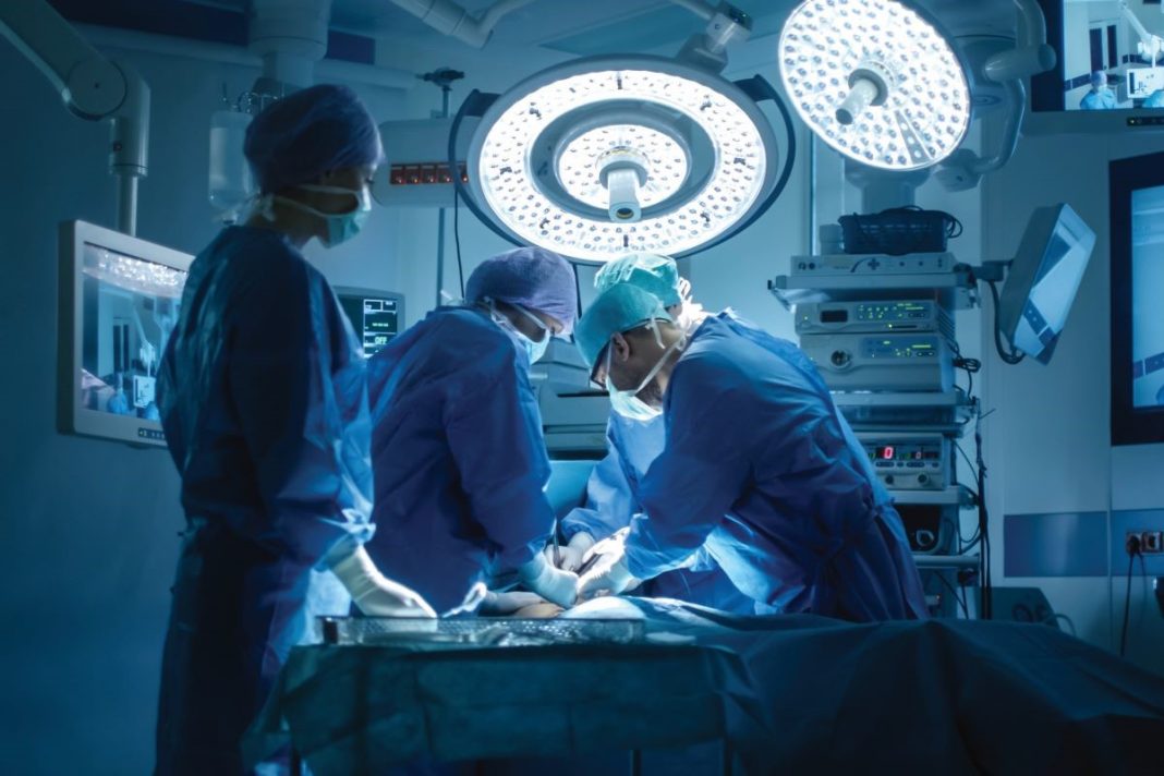 Doctors and nurses surrounding an operating table.